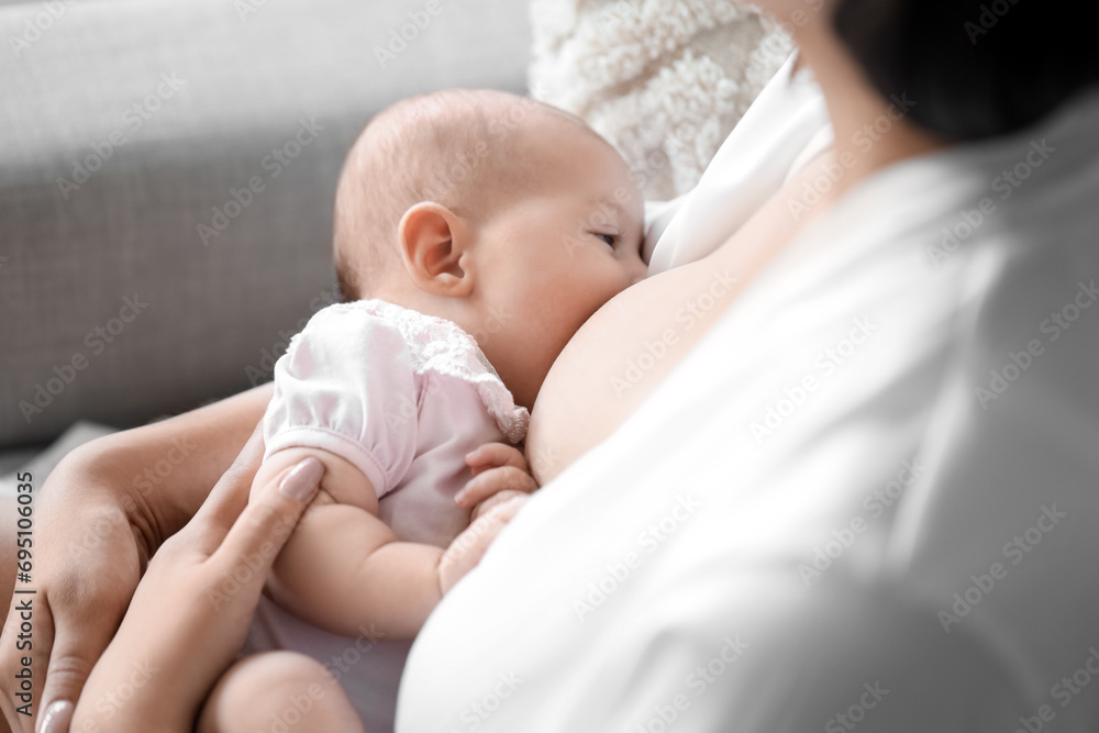 Young woman breastfeeding her baby at home, closeup Young woman breastfeeding her baby at home, closeup