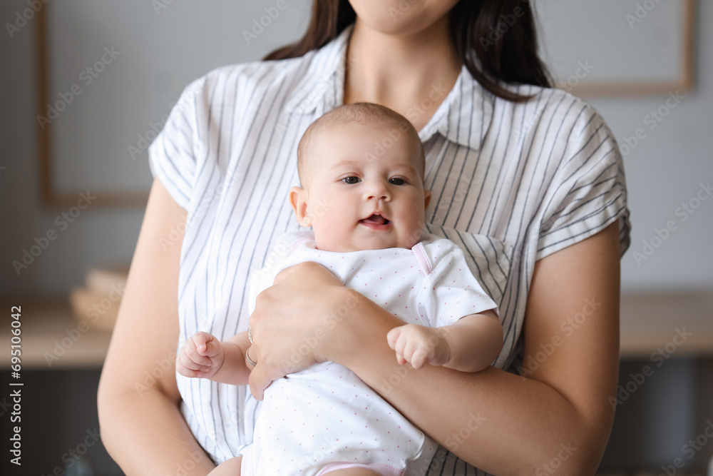 Young woman with her baby at home, closeup Young woman with her baby at home, closeup