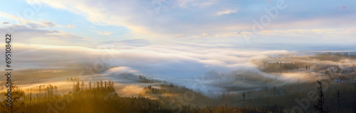 Clouds illuminated by the morning sun floating low over the valley. Country panorama. © wildman