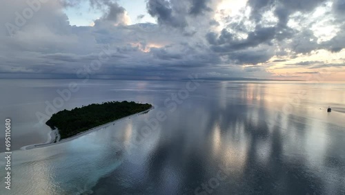 A serene sunrise illuminates the remote island of Koon near Seram, Indonesia. This scenic island's coral reefs, and the surrounding seas, support extraordinary marine biodiversity. photo