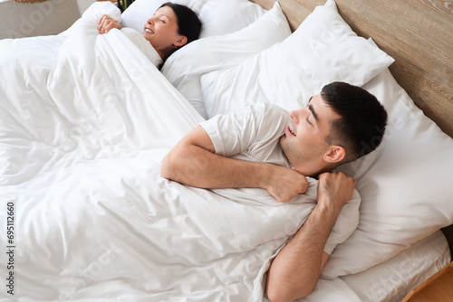 Young couple lying under bl...