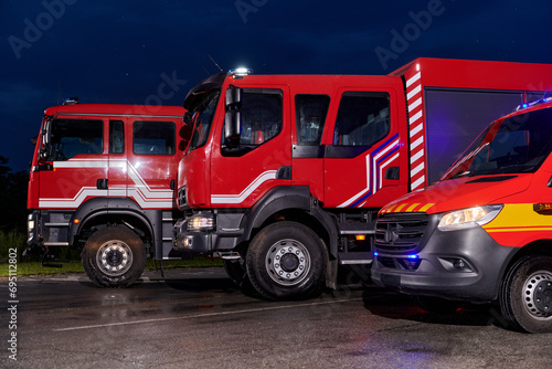 A pair of highly modern and quality fire trucks illuminate the night with their rotating lights  symbolizing the cutting-edge technology and preparedness of the firefighting fleet  ready to respond to
