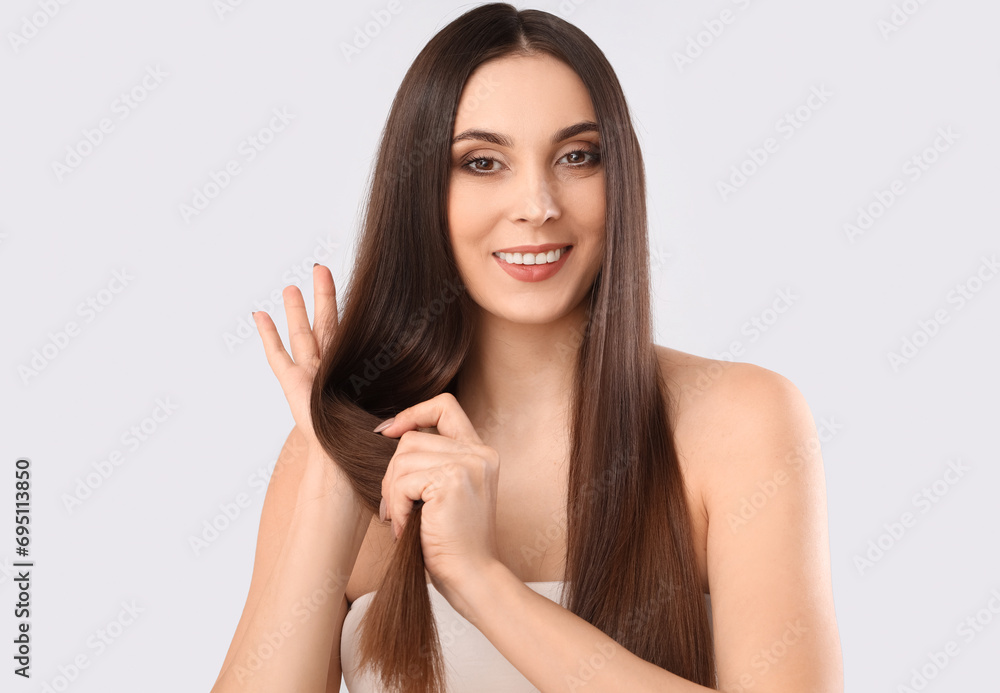 Young brunette woman with long hair on light background Young brunette woman with long hair on light background