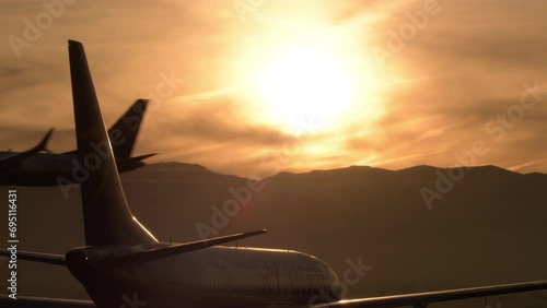 Airplane waiting in runway and airplane landing in airport at sunset photo