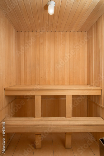 sauna interior. interior of a wooden sauna. wood and warm room. finnish sauna. indoor health space. comfortable and clean hotel sauna. wood interior spa with hot steam. wooden bench texture.relaxation