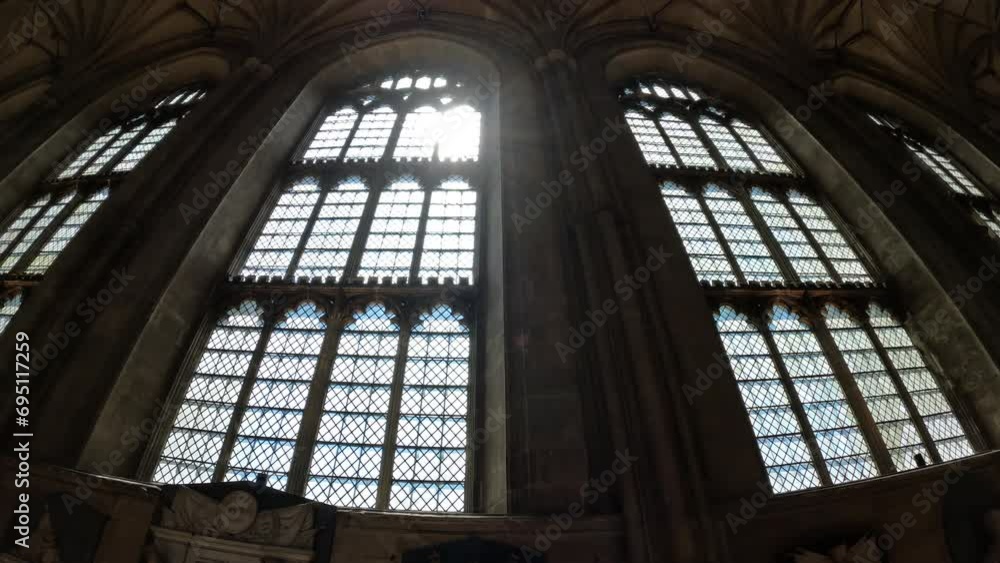 LOW ANGLE VIEW: Bright rays of sunlight shine through the magnificent window. Beautiful architectural details in every corner of the Canterbury Cathedral. Stunning religious and historical monument. LOW ANGLE VIEW: Bright rays of sunlight shine through the magnificent window. Beautiful architectural details in every corner of the Canterbury Cathedral. Stunning religious and historical monument.