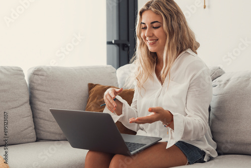 Portrait of young beautiful blonde girl talking with colleagues studying online in class room videocall learning. Working woman in a video conference..