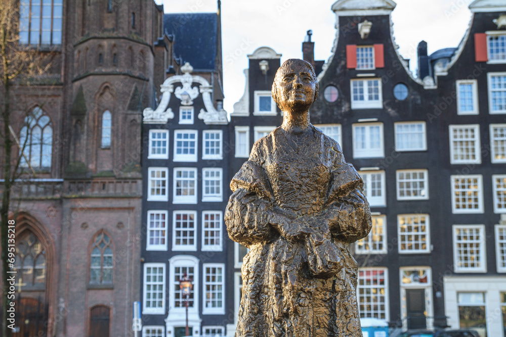 Obraz premium Cityscape - the statue Vrouw met Stola (Woman with stole) is located next to the Siegel canal in the historic center of Amsterdam, the Netherlands
