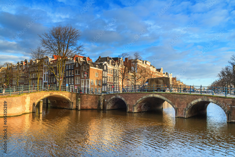 Obraz premium Cityscape on a sunny winter day - view of the bridges and canals in the historic center of Amsterdam, The Netherlands