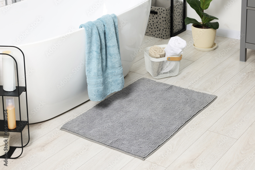 Soft light grey mat near tub in bathroom - obrazy, fototapety, plakaty 