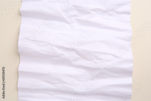 Sheet of crumpled parchment paper on beige background, top view