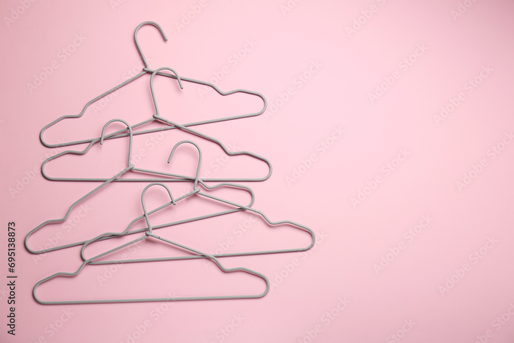 Hangers on pink background, flat lay. Space for text