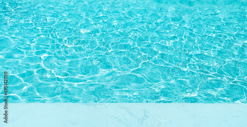 Background of water in swimming pool with copy space on white marble. surface of blue swimming pool. photo