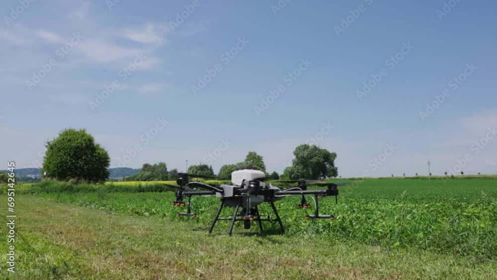 Agricultural drone propellers start spinning and take off near green farmland Agricultural drone propellers start spinning and take off near green farmland