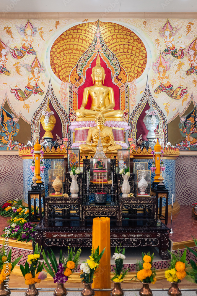 Beautiful buddha statue worship with flowers, incense sticks, candles in chapel, Thai temple.