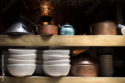Shelf in restaurant with bowls and kettles photo