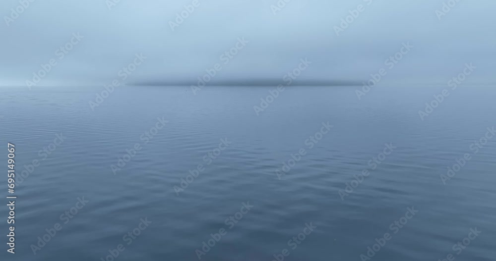 Slow aerial shot, showing a completely covered island in the Japanese sea by fog. Showing the risks during bad weather. Slow aerial shot, showing a completely covered island in the Japanese sea by fog. Showing the risks during bad weather.