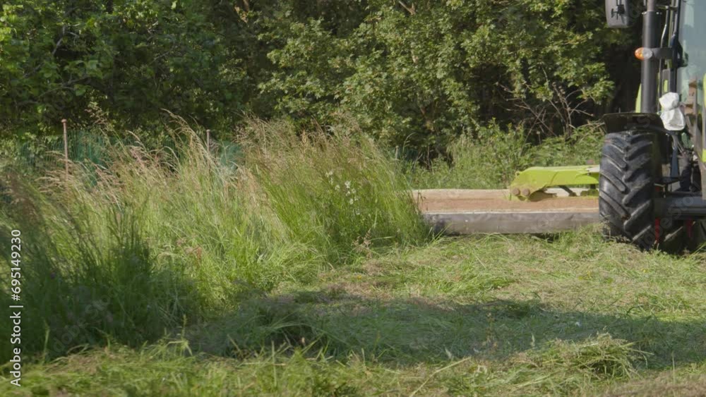 Mowing Tractor Cutting Grass Silage On Field. slow motion shot Mowing Tractor Cutting Grass Silage On Field. slow motion shot