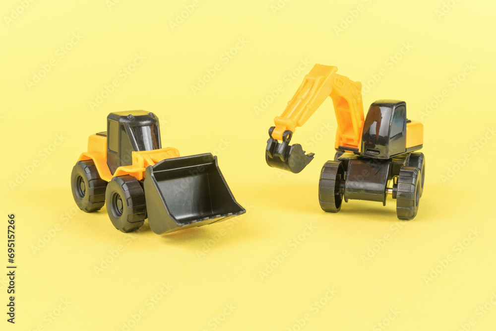 A yellow bulldozer and a yellow excavator on a yellow background.