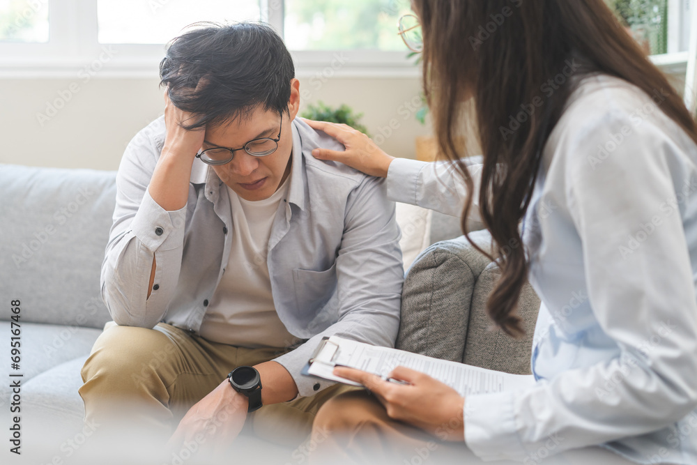 Psychology, depression. Sad, suffering asian young man, male consulting with psychologist, psychiatrist while patient counseling mental problem with doctor at clinic. Encouraging, therapy, health care - obrazy, fototapety, plakaty 