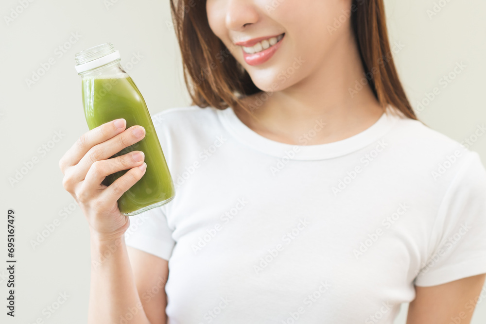 Green detox juice concept, Beautiful asian young woman hand holding vegetable smoothie bottle for diet on background. Happy girl drinking healthy meal food for weight loss. Lifestyle, vegan nutrition. Green detox juice concept, Beautiful asian young woman hand holding vegetable smoothie bottle for diet on background. Happy girl drinking healthy meal food for weight loss. Lifestyle, vegan nutrition.
