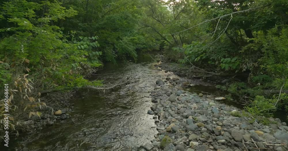 Drone flying slowly through a river bed in the Hokkaido region of Japan. Beautiful nature left and right. Drone flying slowly through a river bed in the Hokkaido region of Japan. Beautiful nature left and right.