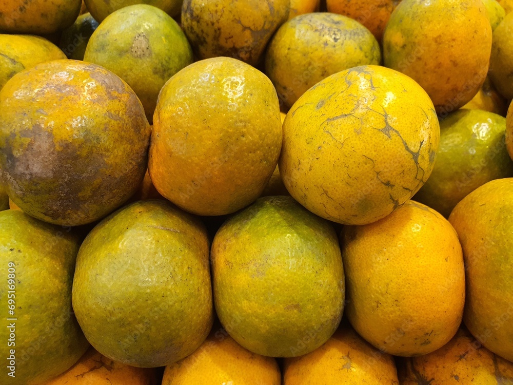 Close up pile of tasty fresh oranges sold at the market as a background.