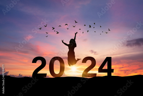 Young woman enjoying and celebrating New Year 2024 with the beautiful sunrise sky and landscape photo