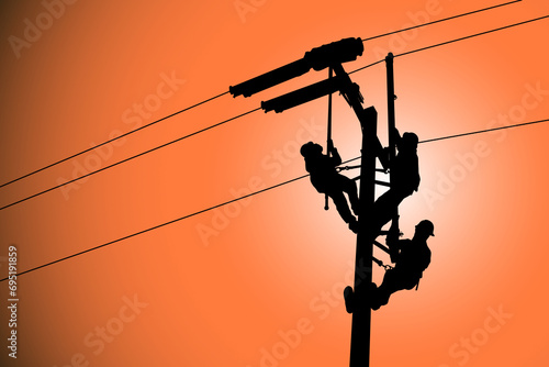 The silhouette of lineman are replacing damaged insulator insulators by using insulated wire-tong sets, tie stick and robe box sets in sliding wires going out in a safety working distance.