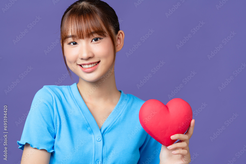 Beautiful asian lady holding a red heart in hands Beautiful asian lady holding a red heart in hands
