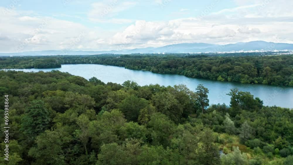 Blue lake between the dense forests of a western European landscape under a cloudy sky, drone aerial view Blue lake between the dense forests of a western European landscape under a cloudy sky, drone aerial view