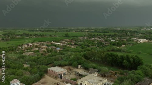 Aerial pan shot of a lush village near Mirpur Khas, Sindh, under stormy skies. photo