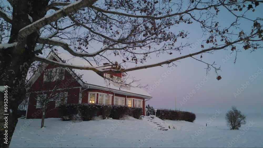 Aerial forward view of a beautiful scandinavian home in a snow..