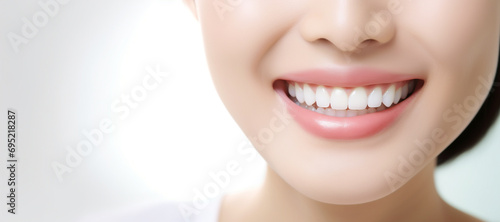 Perfect white teeth smile of young woman with glossy lips, close up. The result of the teeth whitening procedure. Oral care dentistry concept. Tooth whitening, female toothy veneer smile. Stomatology
