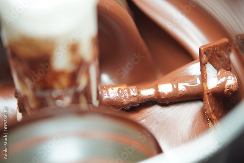 Use a chocolate grinder to grind cocoa beans into liquid chocolate photo