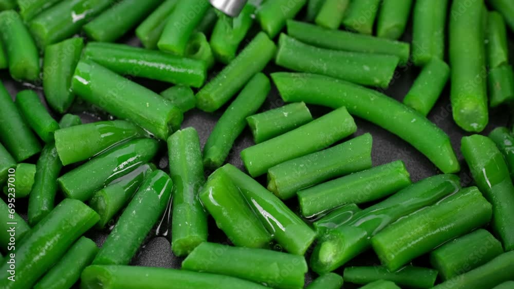 Pouring oil in frying pan with green beans. Healthy vegan food concept Pouring oil in frying pan with green beans. Healthy vegan food concept