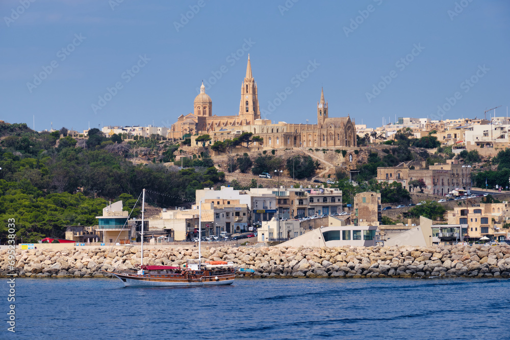 The Ghajnsielem Parish Church and the Our Lady of Lourdes Church high above the harbour - Mgarr, Malta
