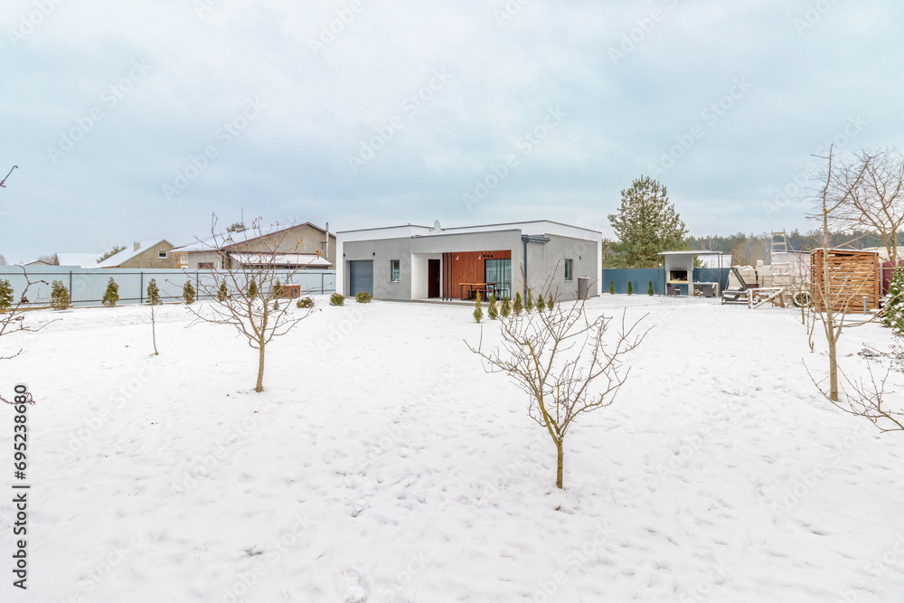 Modern one-storey house with a flat roof in winter