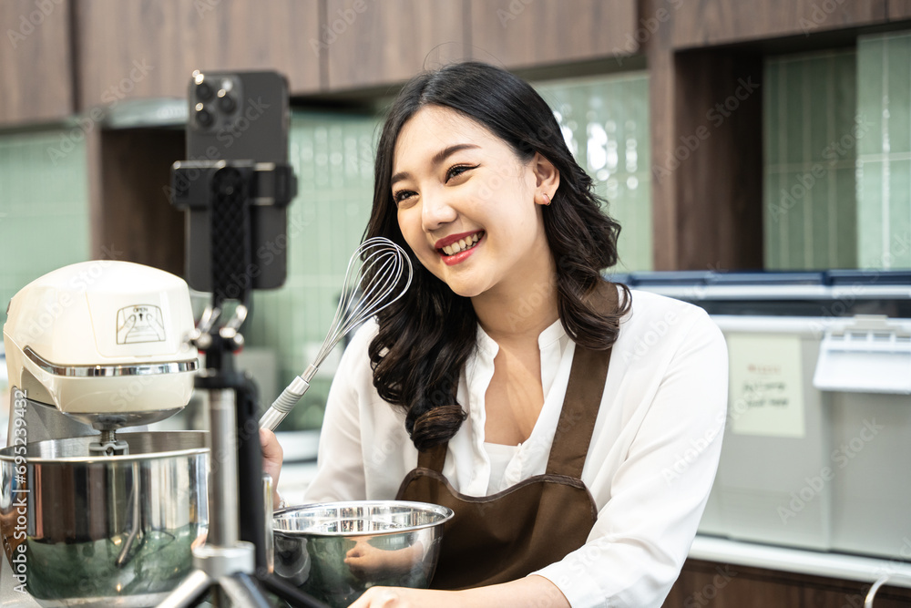 Beautiful young Asian woman uses phone to communicate with online customers at her store. She working with happy emotion at cafe. Beautiful young Asian woman uses phone to communicate with online customers at her store. She working with happy emotion at cafe.