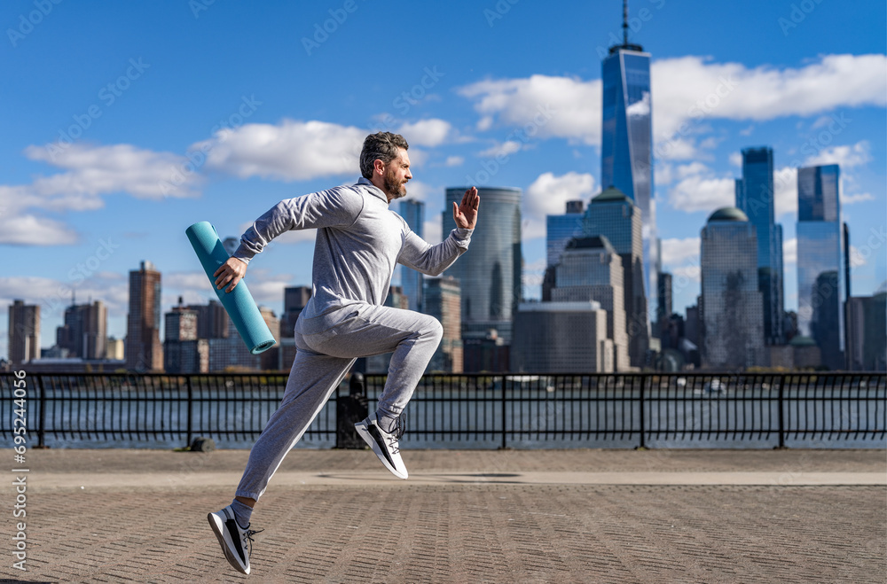 The jogger run at sport training. Sportsman jogger running or jogging. Man in sports suit training jogging. Running man in Manhattan. Morning sport workout jogger run in New York. Individual sports The jogger run at sport training. Sportsman jogger running or jogging. Man in sports suit training jogging. Running man in Manhattan. Morning sport workout jogger run in New York. Individual sports