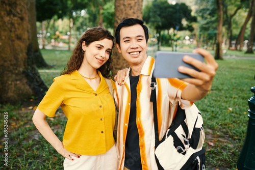 Принти на полотні Happy young couple taking selfie on smartphone when walking in park