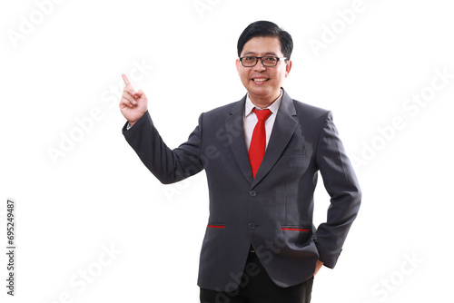 Happy asian businessman standing while pointing sideways. Isolated on white