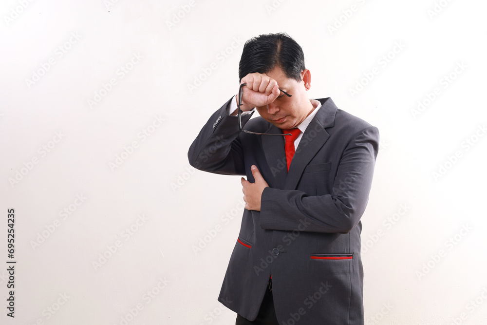 Stressed tired asian businessman standing while holding his head. Isolated on white background Stressed tired asian businessman standing while holding his head. Isolated on white background