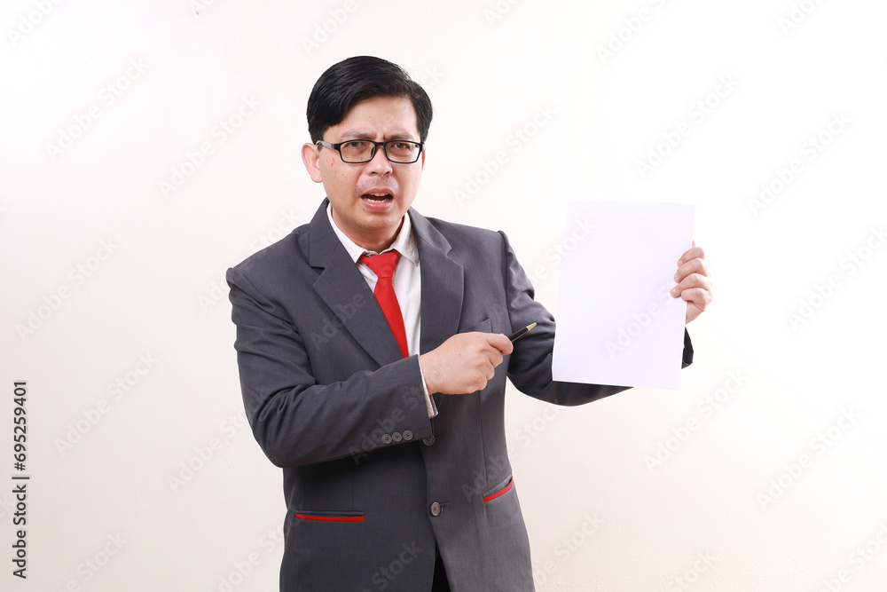 Angry Asian businessman standing while presenting report on a paper. Isolated on white Angry Asian businessman standing while presenting report on a paper. Isolated on white