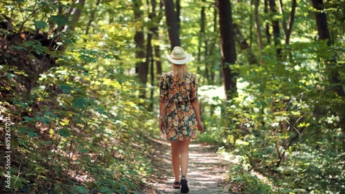Woman in hat exploring  forest . Woman walking in Greenwood  photo