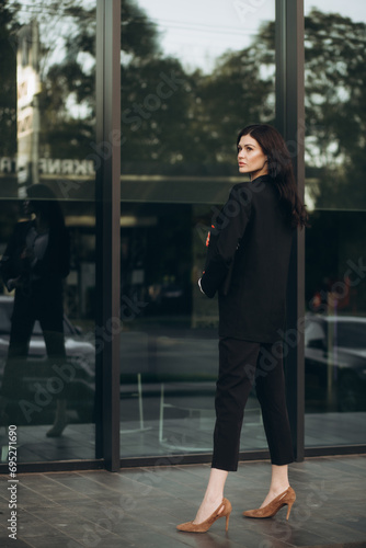 business woman in a suit standing near an office building