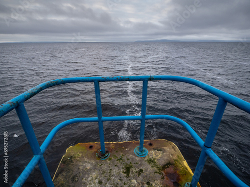 View from Blackrock diving board on Atlantic ocean and Burren mountains in the background. Cloudy dramatic sky. Salthill area of Galway city, Ireland. Popular landmark. photo