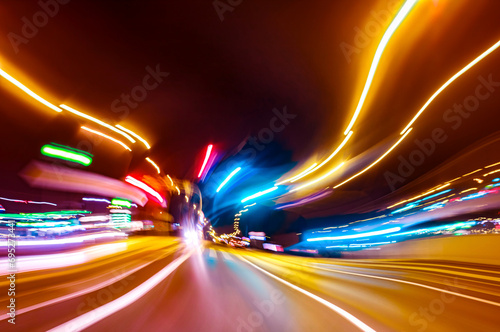 City colorful night lights perspective blurred by high speed of the car. A streak of light, trails.