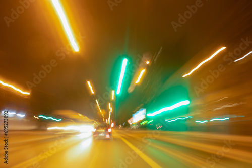 City colorful night lights perspective blurred by high speed of the car. A streak of light, trails.