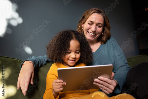 Mother and daughter using a digital tablet in evening light photo